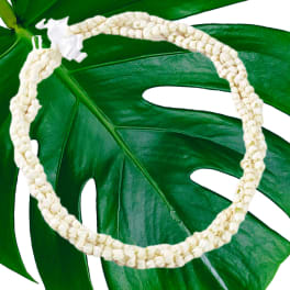 White flower lei on a large green leaf