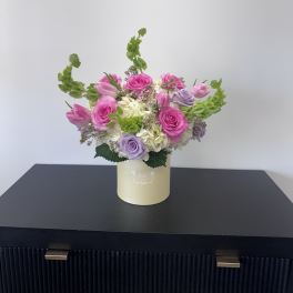 Pink and lavender roses with tulips in a cream box