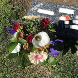 Bouquet of mixed flowers placed beside a gravestone