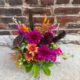 Bright mixed bouquet with magenta and orange flowers and dark decorative accents