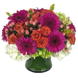 Bouquet of magenta gerbera daisies and orange roses in a green vase