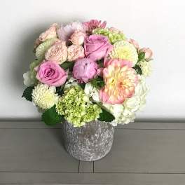 Pink and white mixed flowers arranged in a gray vase