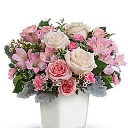 Pink and white rose bouquet in a clear square vase