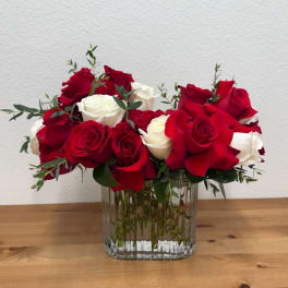 Red and white roses arranged in a clear glass vase