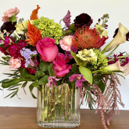 Mixed bouquet in a clear glass vase with pink, orange, and cream blooms