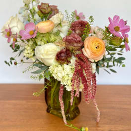 Mixed pastel bouquet in an amber glass vase