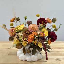 Mixed floral arrangement in a white pumpkin-shaped vase
