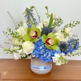 Blue and white floral arrangement in a gray vase