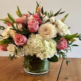 Pink roses and white hydrangeas arranged in a glass vase