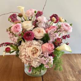 Pink and cream floral arrangement in a glass vase