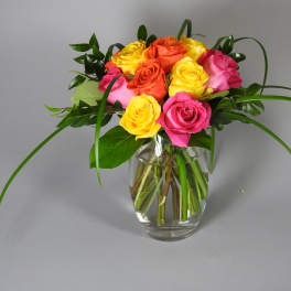 Bouquet of multicolored roses in a clear glass vase