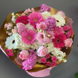 Pink and white mixed bouquet with gerbera daisies and roses wrapped in gold paper