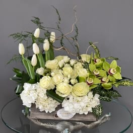 White tulips, roses, hydrangeas, and green orchids in a wooden box