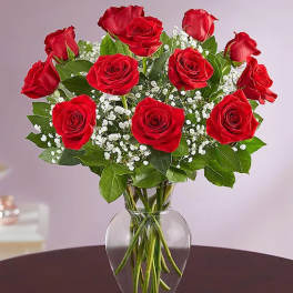 Red roses with baby's breath in a clear glass vase