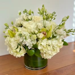 White floral arrangement in a green glass vase
