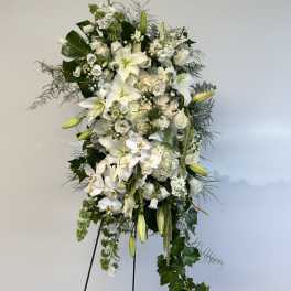 Tall white floral standing spray on a black easel