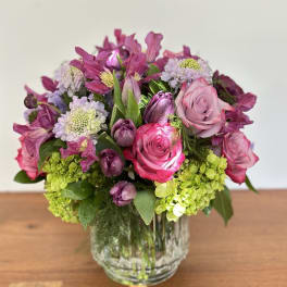 Pink and purple flower arrangement in a clear glass vase