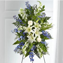 Standing floral spray with white lilies, roses, and blue flowers