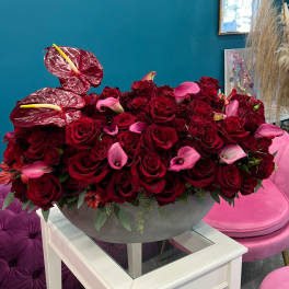 Red roses and pink calla lilies in a gray bowl centerpiece