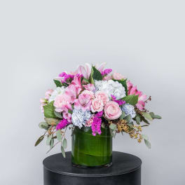 Pink and white mixed bouquet in a green glass vase