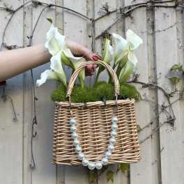 Wicker basket with white calla lilies and pearl handles