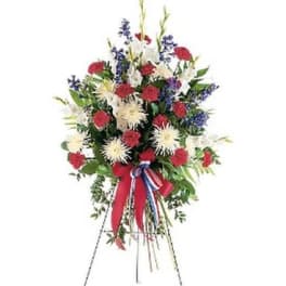 Standing floral spray with red, white, and blue flowers on an easel