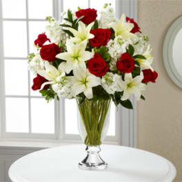 Red roses and white lilies in a clear glass vase