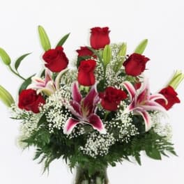 Red roses and pink lilies arranged in a glass vase