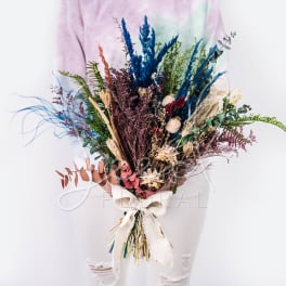 Dried bouquet with blue, purple, and pink stems tied with a white ribbon