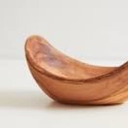 Curved wooden bowl on a plain light background