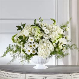 White floral arrangement in a white pedestal vase