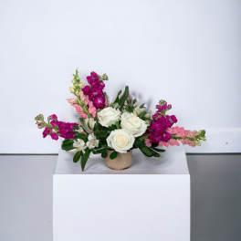 Arrangement of white roses and pink flowers in a small vase