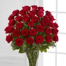 Tall bouquet of red roses in a clear glass vase