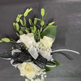 White rose bouquet with black and silver ribbon on a dark background