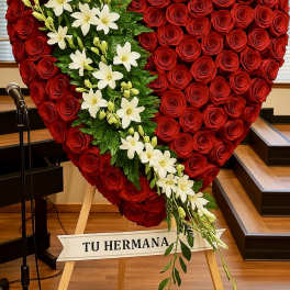 Large heart-shaped standing spray of red roses with a diagonal cascade of white lilies.