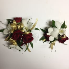 Two small floral corsages with red roses and white orchids