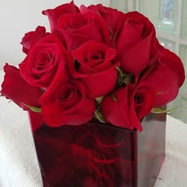 Red roses arranged in a square glass vase