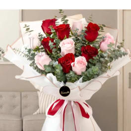 Bouquet of red and pale pink roses wrapped in white paper