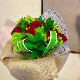 Bouquet of red roses wrapped in burlap with green ribbon