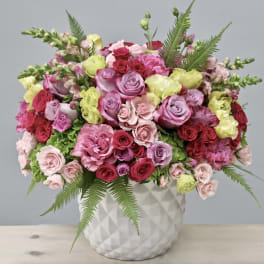 Mixed pink and red roses in a white textured vase