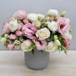 Pink and white mixed flower arrangement in a gray vase
