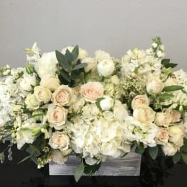 Cream and white floral arrangement in a gray wooden box