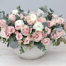Pink and white rose arrangement in a white vase