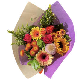 Bright mixed bouquet with gerbera daisies, roses, and chrysanthemums in purple wrap