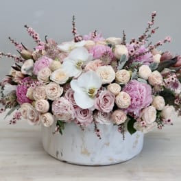 Pink and white floral arrangement in a round white vase