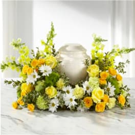 Yellow and white floral wreath around a silver urn