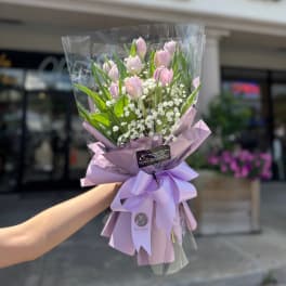 Pink tulip bouquet wrapped in lavender paper with a ribbon