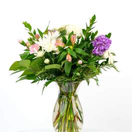 Mixed bouquet of white mums, pink alstroemeria, and a purple carnation in a clear glass vase