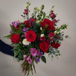 Hand-tied bouquet of red roses and purple flowers