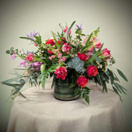 Mixed bouquet of pink and purple flowers in a striped glass vase